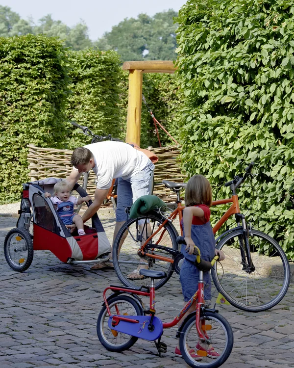 Kloster Hornbach: Ihr fahrradfreundliches Hotel in der Pfalz Vater überprüft kleines Kind im Fahrradanhänger, anderes Kind mit Laufrad daneben