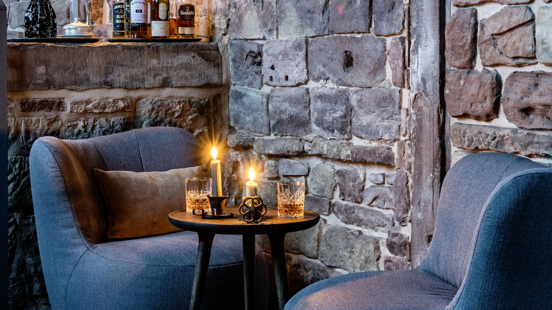 Treffpunkt, Kraftplatz und Hotel in Hornbach Gemütliche Sitzecke mit Kerzenlicht und Flaschen vor einer Steinwand