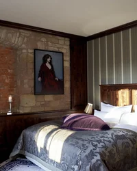 Kloster Hornbach: Ihre Ansprechperson für Medienanfragen Gemütliches Schlafzimmer mit Vintage-Dekor, Steinwand und Bett mit gemustertem Überwurf