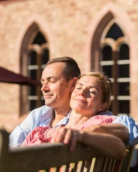 Kloster Hornbach und Lösch: Downloads Mann und Frau genießen entspannt die Sonne auf einer Bank vor einem Gebäude