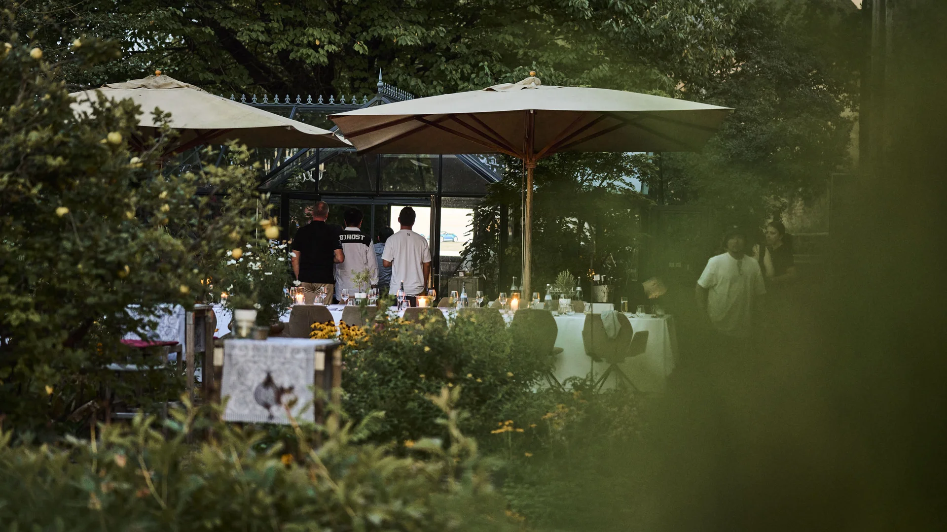 Treffpunkt, Kraftplatz und Hotel in Hornbach Abendessen im Garten mit gedecktem Tisch und Sonnenschirmen bei Dämmerung