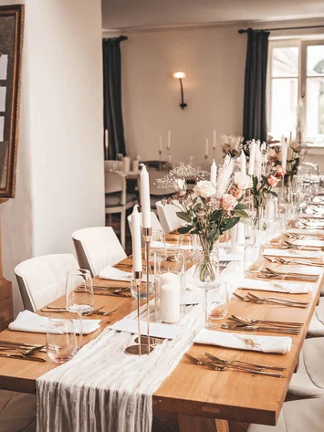 Our venue, your dream wedding Elegant long dining table set with flowers and candles in a modern dining room