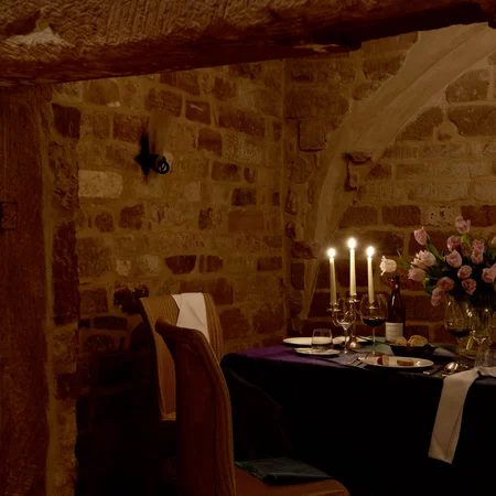 Veranstaltungen im Kloster Hornbach Gemütliches Esszimmer mit Kerzenlicht, Wein und Blumen in einem Steingewölbe