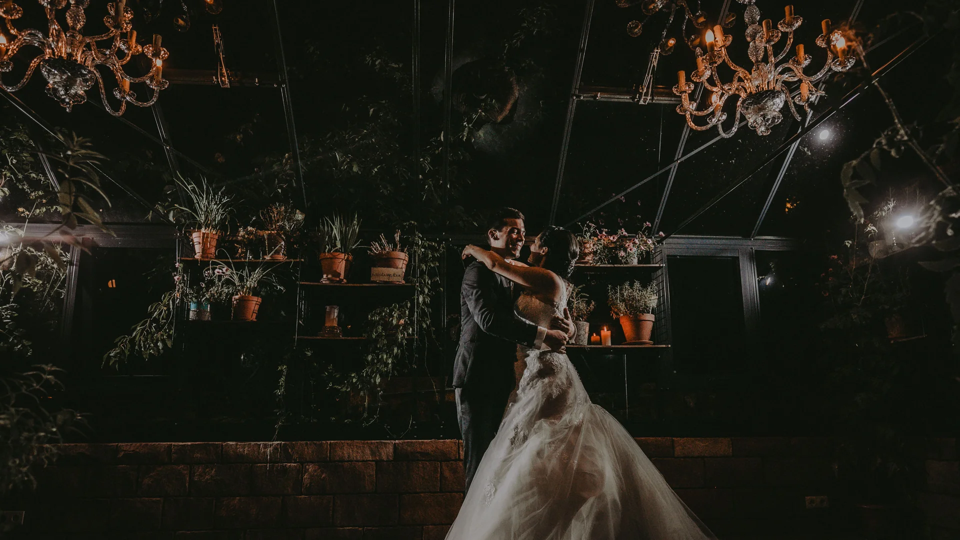 Freie Trauung in der Traumlocation in Rheinland-Pfalz Brautpaar tanzt romantisch bei Nacht unter Kronleuchtern und Pflanzen