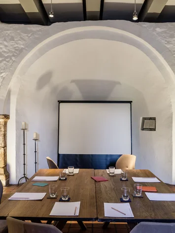 Tagungsräume Pfalz | Historische & moderne Räume im Kloster Hornbach Moderner Meetingraum mit Tischen, Stühlen, Notizblöcken und Projektionswand