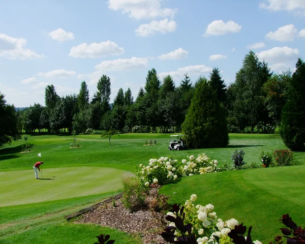 Ausflugstipps für Ihren Urlaub in der Pfalz Golfplatz mit Golfer, Bollerwagen und blühendem Garten bei sonnigem Wetter