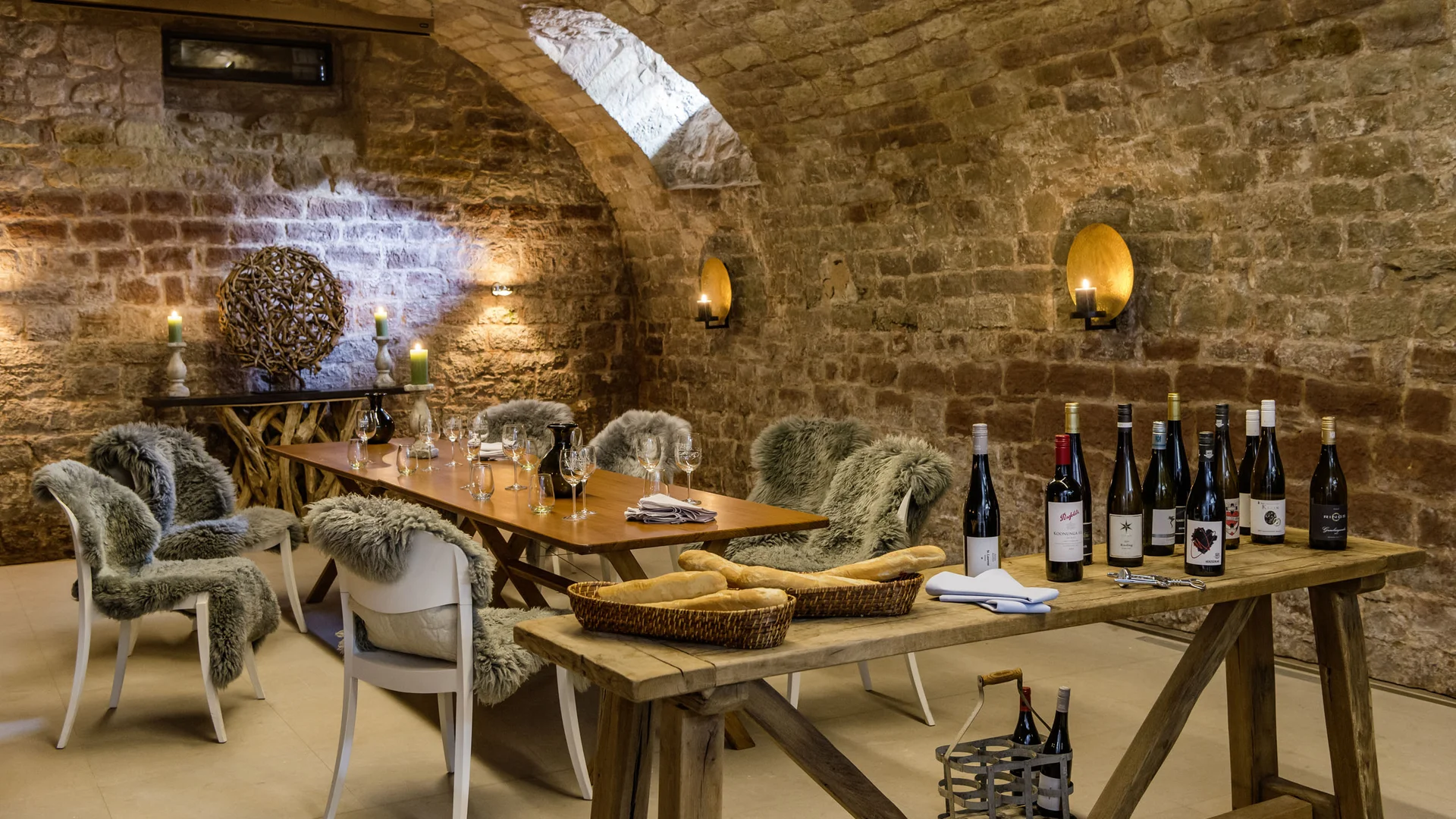 Kulinarik im Lösch: Gaumenfreuden der besonderen Art Gemütlicher Weinkeller mit Holztischen, Weinflaschen, Brot und Stühlen mit Fellbezügen