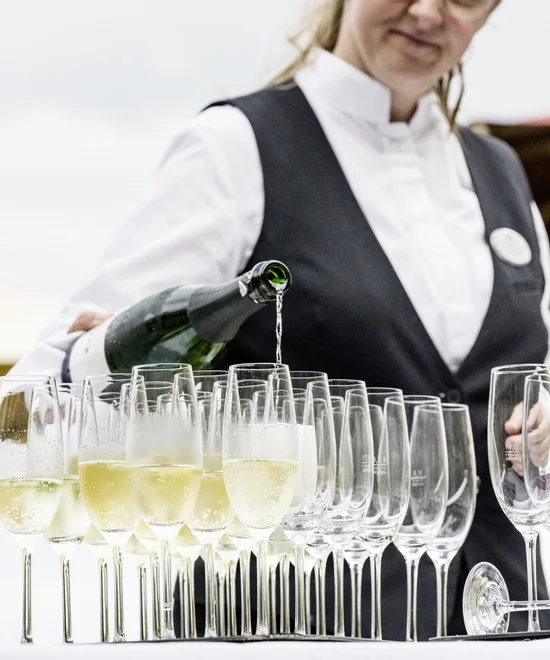 Treffpunkt, Kraftplatz und Hotel in Hornbach Kellnerin gießt Sekt in mehrere Reihen von Gläsern