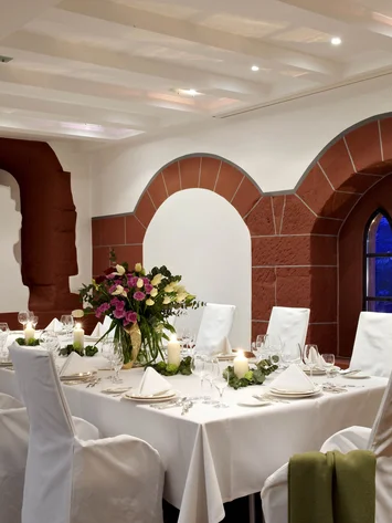 Our venue, your dream wedding Elegant dining area with white table setting and candlelight by arched windows