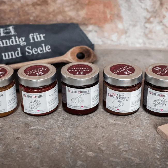 Treffpunkt, Kraftplatz und Hotel in Hornbach Fünf kleine Marmeladengläser mit verschiedenen Fruchtaufstrichen auf Steinboden