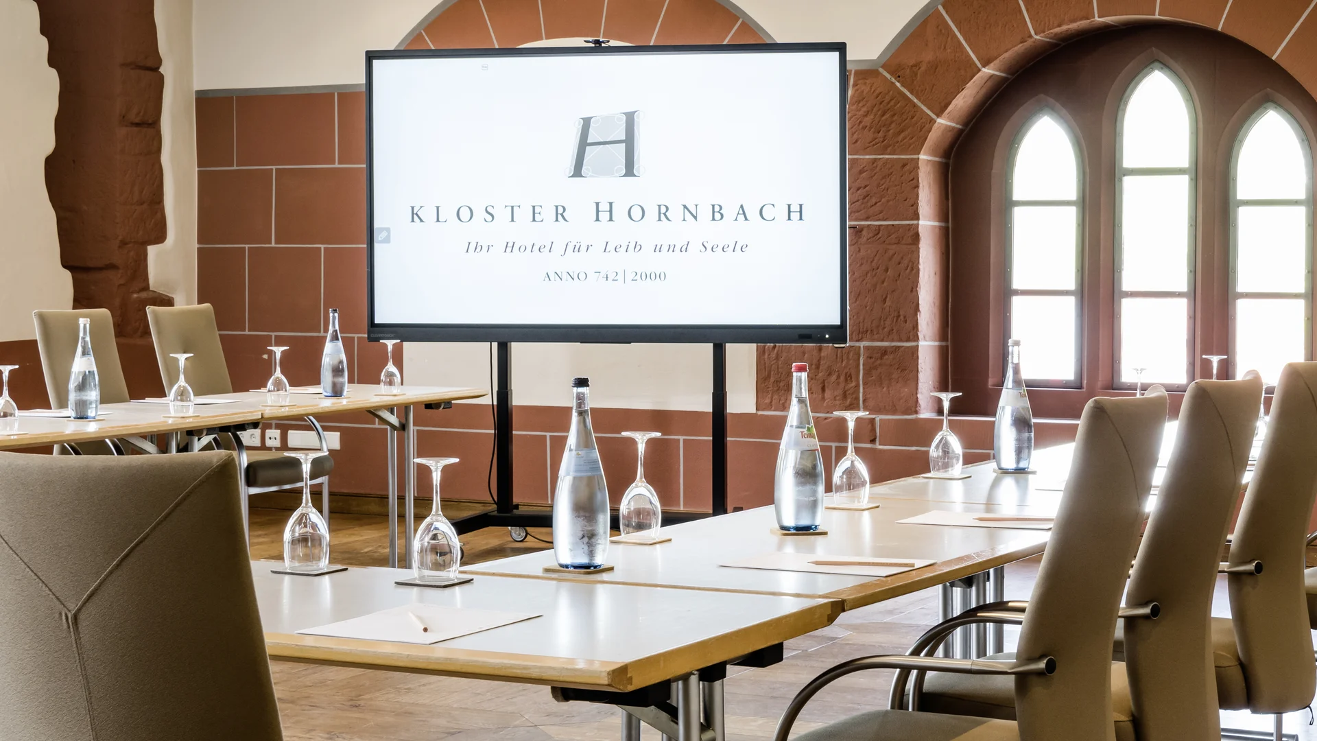 Tagungsräume Pfalz | Historische & moderne Räume im Kloster Hornbach Moderner Konferenzraum mit Bildschirm und bestuhltem Tisch in Kloster Hornbach