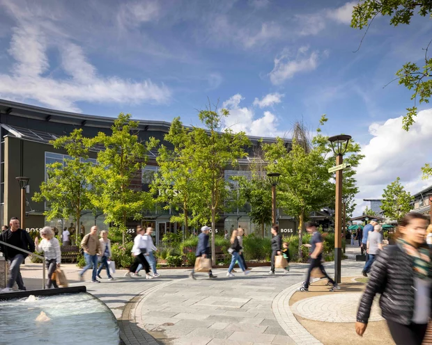 Ausflugstipps für Ihren Urlaub in der Pfalz Menschen gehen im Freiluft-Einkaufszentrum an Bäumen und Brunnen vorbei