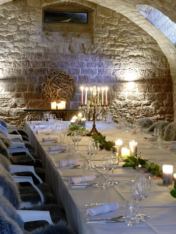 Räume für besondere Anlässe im Kloster Hornbach Eleganter Tisch in einem steinernen Gewölbekeller mit Kerzen und Fellen